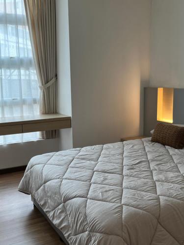 a bedroom with a large bed and a window at Leegarden Apartment-3BR in Sibu