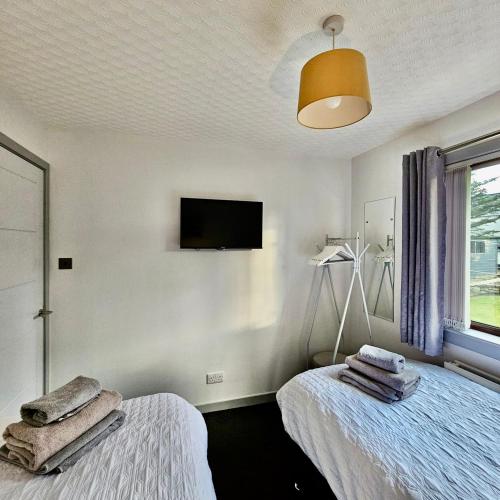 a bedroom with two beds with towels on them at BAYVIEW in Stornoway