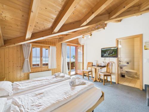 a bedroom with a large bed and a desk at Hotel Wildbach Brienz - Self Check-in in Brienz