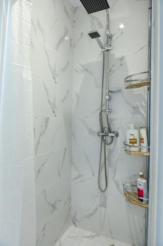 a bathroom with a shower with white marble at Solaris Apartment in Bitola