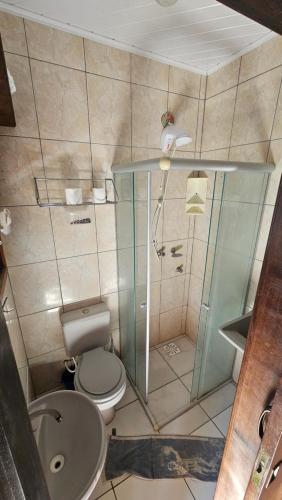 a bathroom with a toilet and a sink and a shower at Tranquilidade a 4 minutos da praia - Com Estacionamento Rotativo in Tramandaí