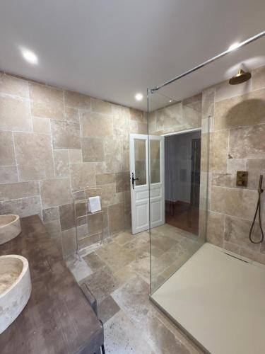 a bathroom with a glass shower and a sink at Maison Lama in Lama