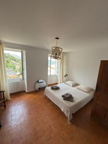 a white bedroom with a bed and a window at Maison Lama in Lama