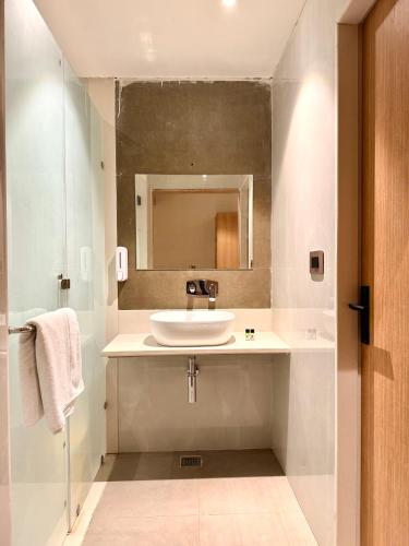 a bathroom with a sink and a mirror at Krishnam Resort in Jabalpur