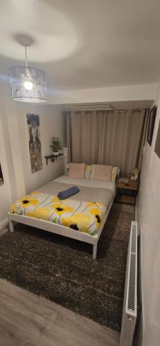 a bedroom with a bed with yellow and white sheets at The Shinki House in Nottingham