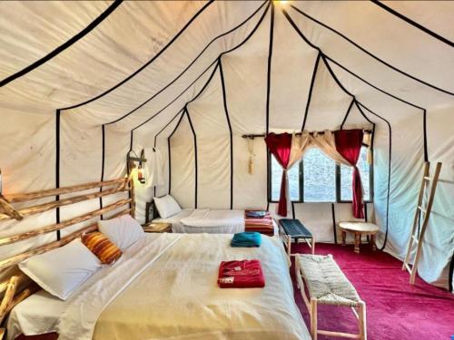 a bedroom with a bed in a tent at Luxury Dune's Camp in Merzouga