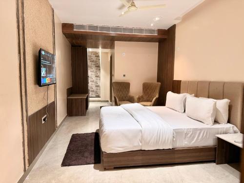 a hotel room with a bed and a tv at Krishnam Resort in Jabalpur