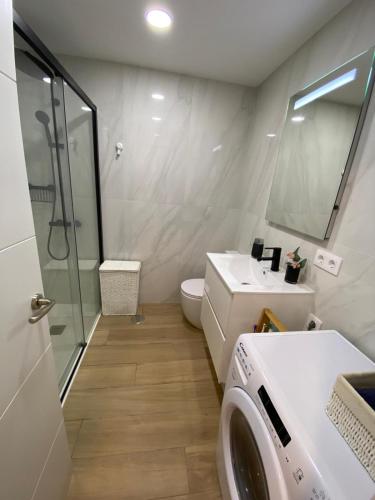 a bathroom with a sink and a washing machine at Ocean Front Cura Beach in Playa del Cura
