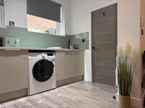 a kitchen with a washing machine in a kitchen at Northern apartments in Sheffield