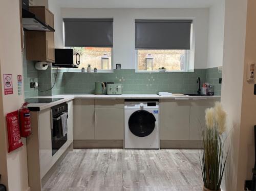 a kitchen with a washing machine in the middle at Northern apartments in Sheffield