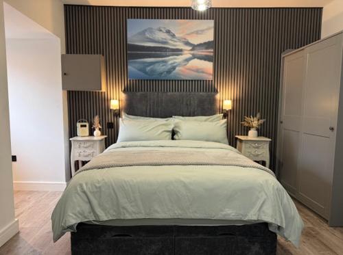 a bedroom with a large bed with a painting on the wall at Northern apartments in Sheffield