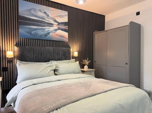 a bedroom with a large bed with a painting on the wall at Northern apartments in Sheffield