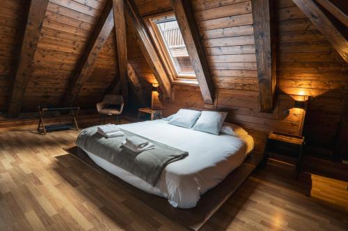 a bedroom with a bed in a wooden cabin at La Borda del Gato Rafa in Vielha