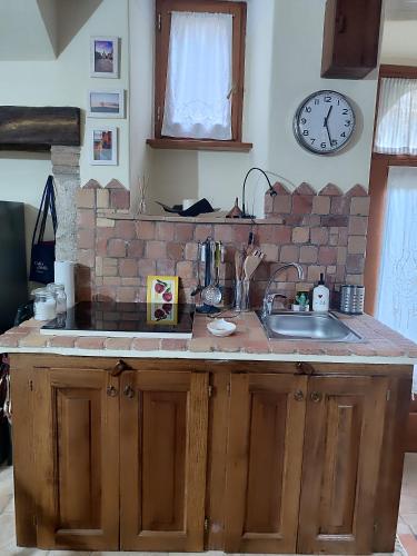 a kitchen with a sink and a brick wall at LA BICO' in Pitigliano