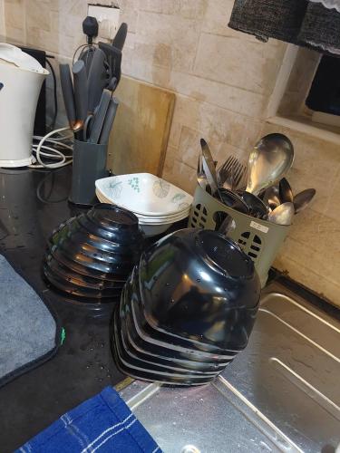 a counter top with plates and a basket of utensils at Kukis Place, 5 bedrooms, whole compound in Embu