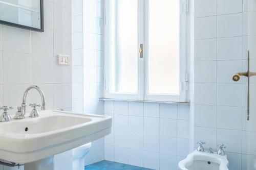 ein weißes Badezimmer mit Waschbecken und Toilette in der Unterkunft Lion Renting Metro Piramide in Rom