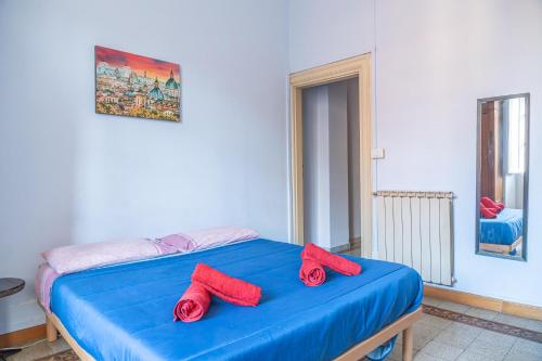 ein blaues Bett mit roten Hausschuhen darauf in der Unterkunft Lion Renting Metro Piramide in Rom