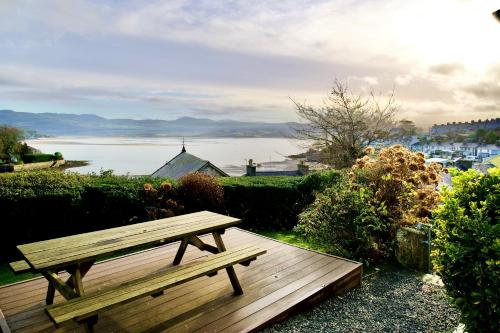 a wooden bench sitting on top of a wooden deck at Bryn Gwyn, Sleeps 8, Sea Views, Borth y Gest in Porthmadog