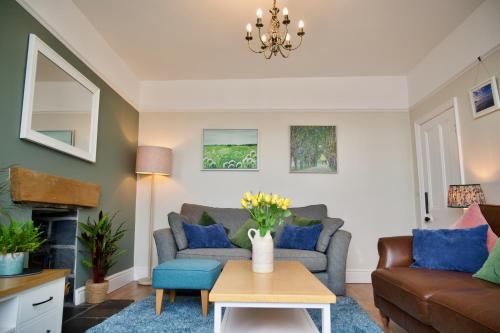 a living room with a couch and a table at Bryn Gwyn, Sleeps 8, Sea Views, Borth y Gest in Porthmadog