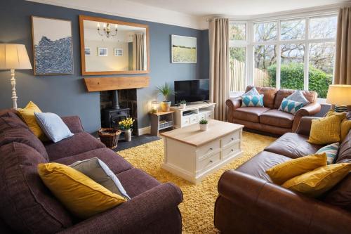 a living room with two couches and a television at Tegfryn (Sleeps 8), 5*, Sea View, Borth y Gest in Porthmadog