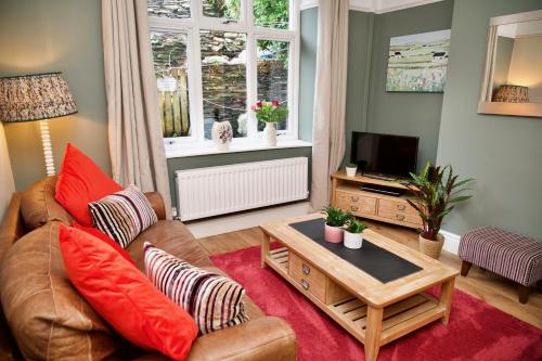 a living room with a couch and a tv at Tegfryn (Sleeps 8), 5*, Sea View, Borth y Gest in Porthmadog