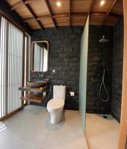 a bathroom with a white toilet and a sink at Santhi Loka in Kubupenlokan