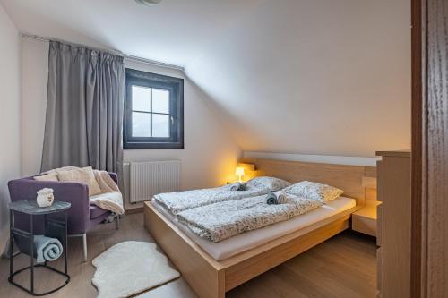 a bedroom with a bed and a chair at Chata Drienka in Terchová