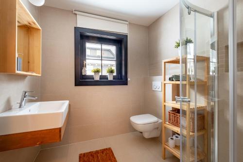 a bathroom with a sink and a toilet and a window at Chata Drienka in Terchová