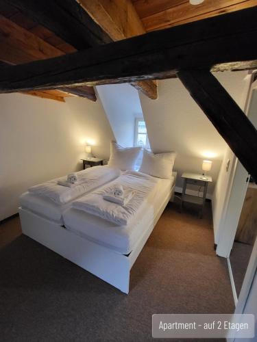 a bedroom with a white bed in a attic at Anno 1577 - Marktkirchhof 6 in Quedlinburg