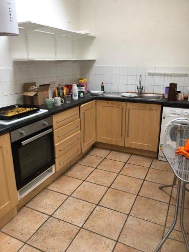 a kitchen with wooden cabinets and a stove top oven at Soho Accommodation in Newry