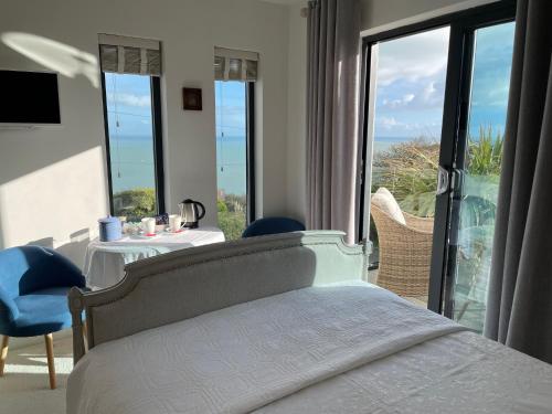 a bedroom with a bed and a view of the ocean at Seagulls Boutique Lodgings in Mevagissey