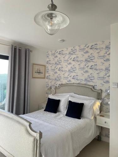 a bedroom with a bed with blue and white wallpaper at Seagulls Boutique Lodgings in Mevagissey