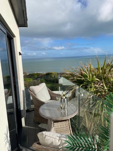 a balcony with a table and chairs and the ocean at Seagulls Boutique Lodgings in Mevagissey