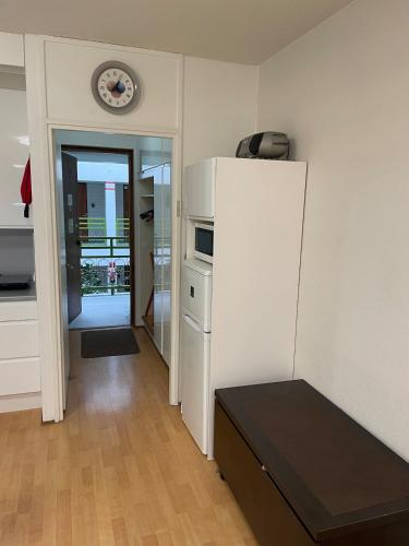 a kitchen with a refrigerator and a clock on the wall at Kylpylä-hotelli 261 in Ikaalinen