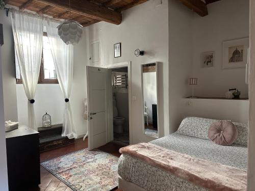 a bedroom with a bed and a window and a mirror at Live As Florentine in Florence