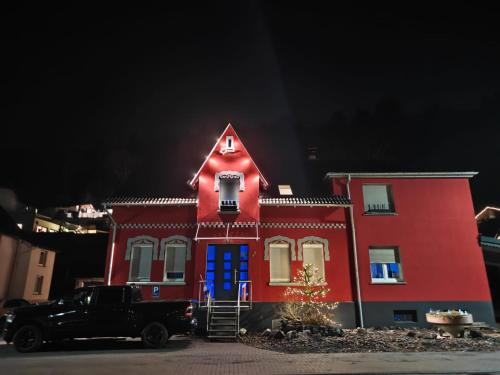 a truck parked in front of a red house with a blue door at Wunderschönes Sauerland in Plettenberg