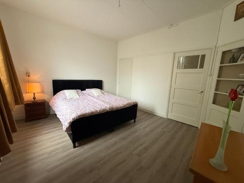 a bedroom with a bed and a window and a door at Authentic sleeping in the city center in Leeuwarden
