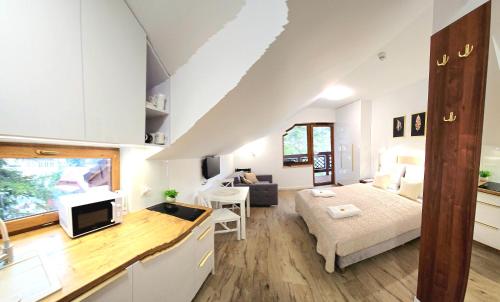 a large white room with a bed and a kitchen at Holiday Family Raj pod Sosnami centrum miasta! in Szklarska Poręba