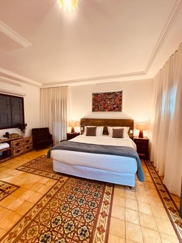 a bedroom with a large bed and a rug at Cadivó Chalé Lavras Novas in Ouro Preto