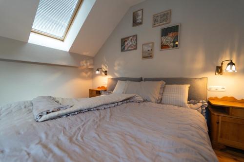 a bedroom with a large white bed with a window at CHALET MACESEN Apartment Mauro with sauna - in the center of Kranjska gora in Kranjska Gora