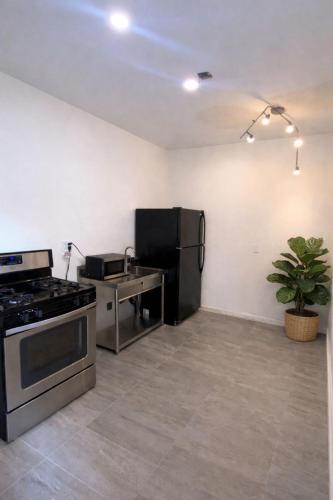 a kitchen with a black refrigerator and a stove at Pickford Vibe near Beverly Hills in Los Angeles