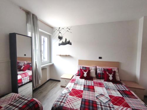 a bedroom with two beds and a mirror at Superior Apartments Giovannini in Fai della Paganella