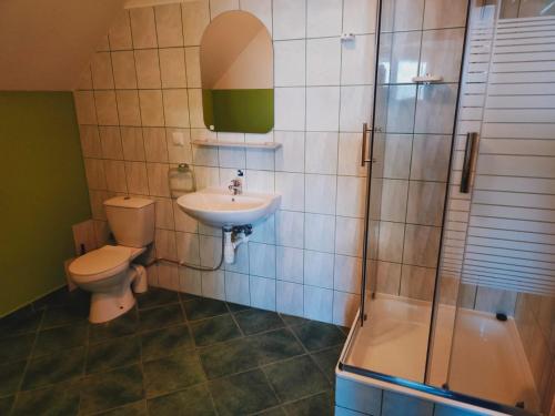a bathroom with a toilet and a sink and a shower at JODA Pokoje Goscinne in Rewal