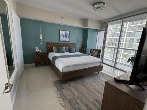 a bedroom with a bed and a flat screen tv at Sun&Sea IconBrickell Unit in Miami