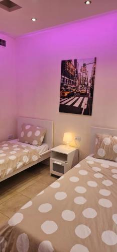 two beds in a room with purple lighting at 2 bedrooms apartment no 13 in Amman