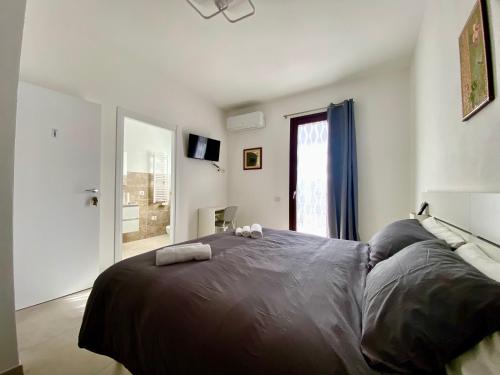 a bedroom with a large bed with two towels on it at Rooms Domu Ajo in Monserrato