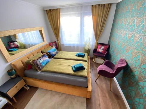 a bedroom with a bed and a mirror and a chair at Deluxe Suite in Vienna