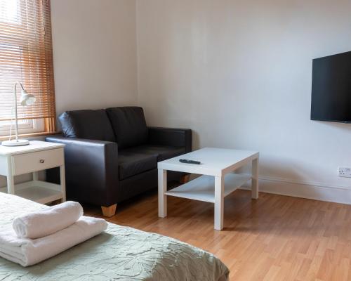 a living room with a couch and a table at Studio apartment next to Highgate tube station in London