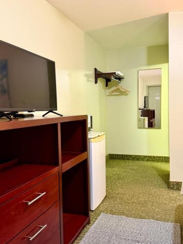 a living room with a flat screen tv on a entertainment center at Rocky Mountain Lodge & Suites in Renfrew