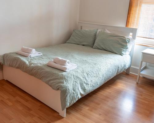 a bedroom with a bed with two towels on it at Studio apartment next to Highgate tube station in London